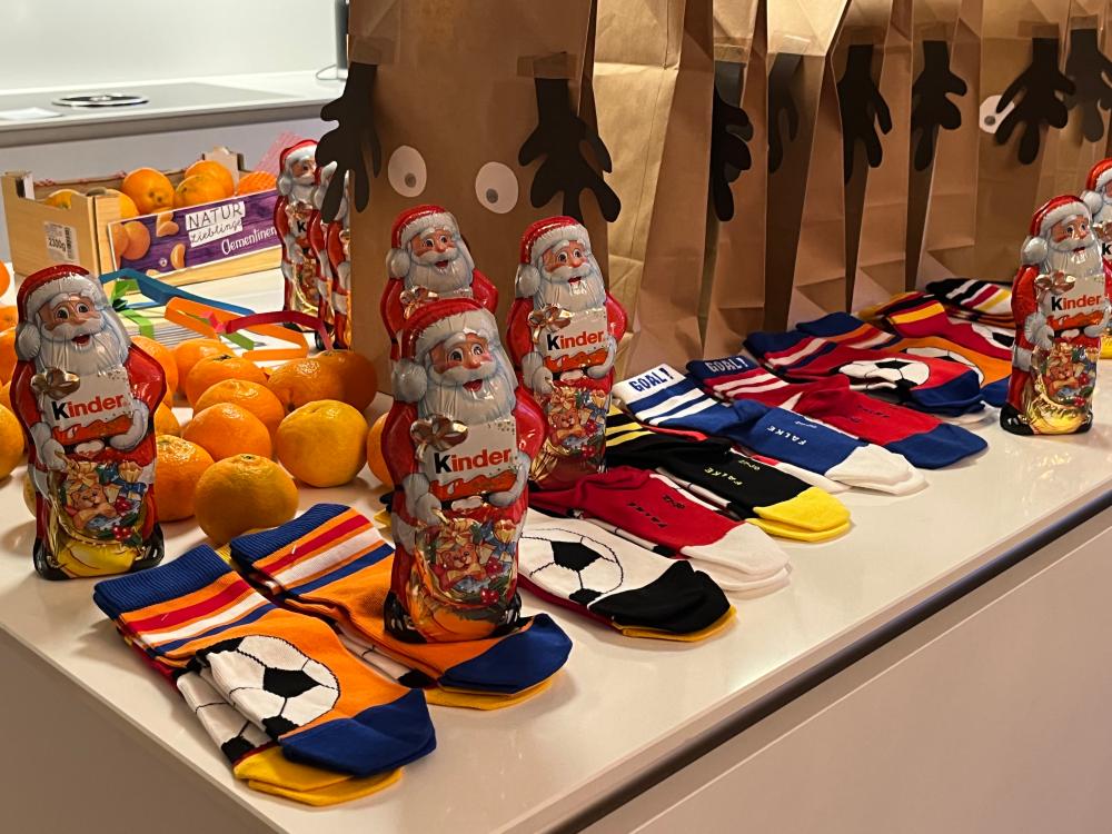 Weihnachtstüten auf einen Tisch mit Socken, Schokoweihnachtsmänner und Mandarinen